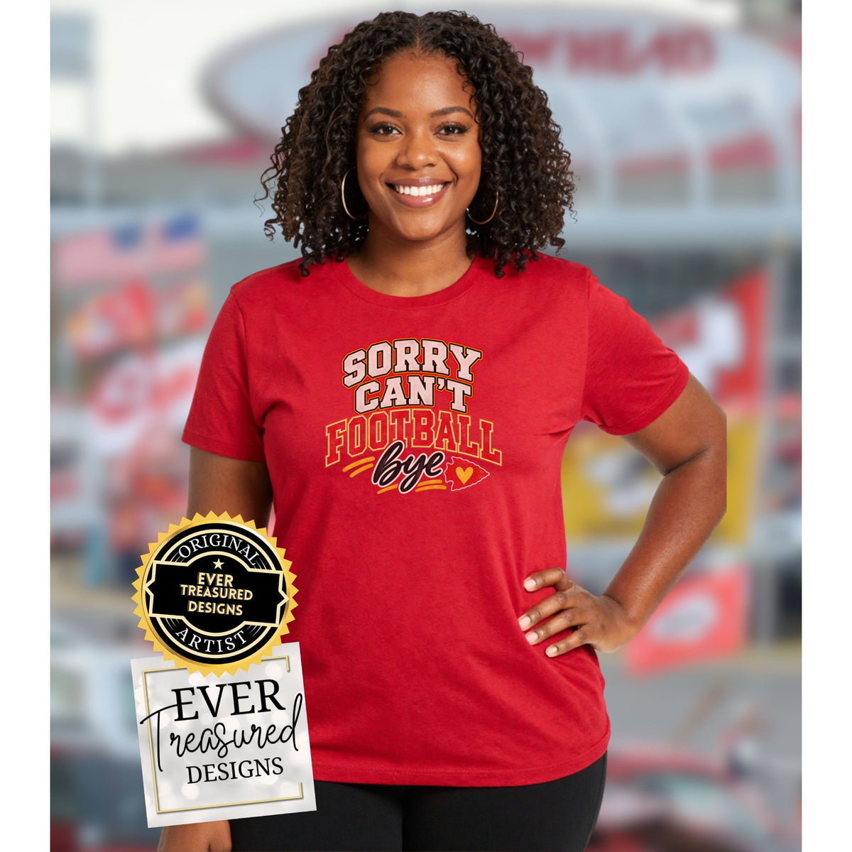 Red t-shirt with "Sorry Can't Football Bye" text and a heart-shaped arrowhead.