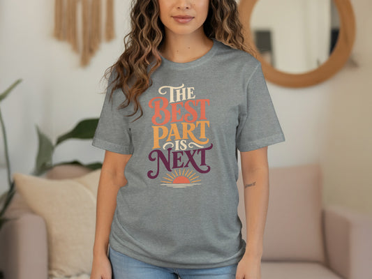 Grey t-shirt with text "The BEST PART is NEXT" and a sun graphic.