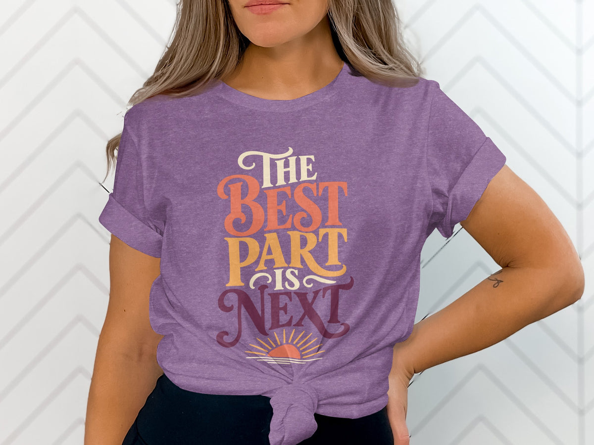 Purple t-shirt with text "The Best Part Is Next" and a sunrise graphic.