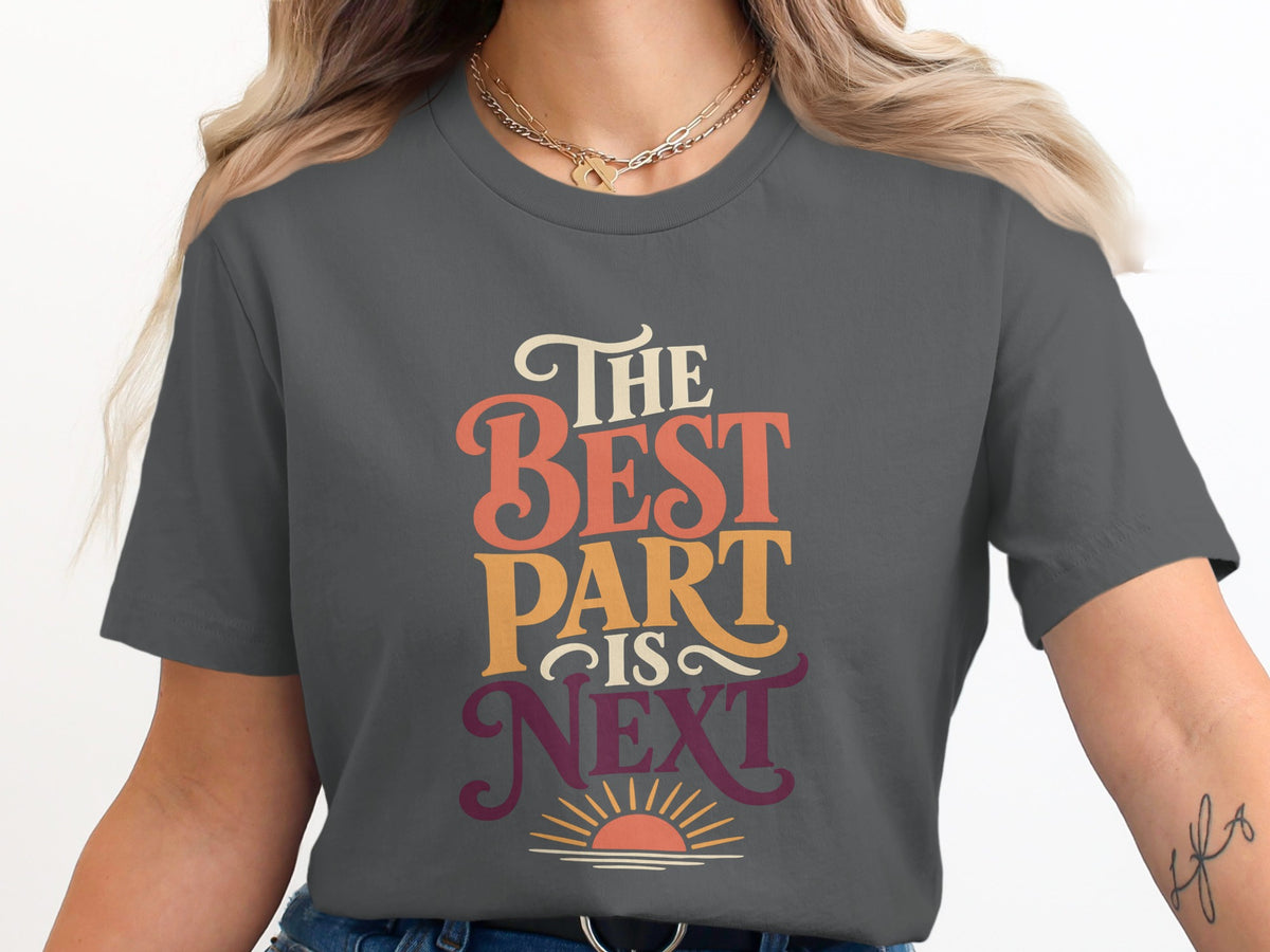 Dark grey t-shirt with text "The Best Part Is Next" and a sunrise graphic.