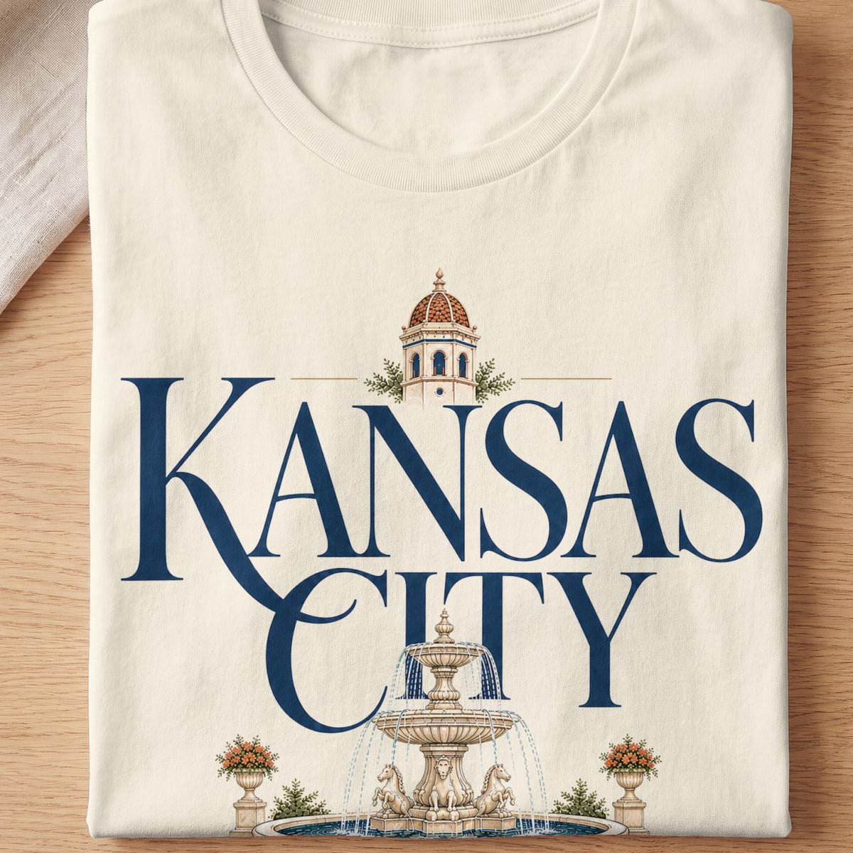 Cream t-shirt with "KANSAS CITY" text, a tower, and a fountain graphic.