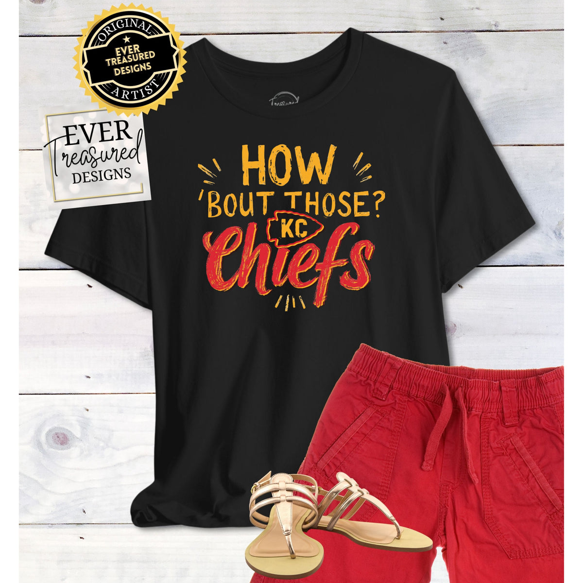 Black t-shirt with "HOW 'BOUT THOSE? KC Chiefs" graphic, red shorts, and gold sandals.
