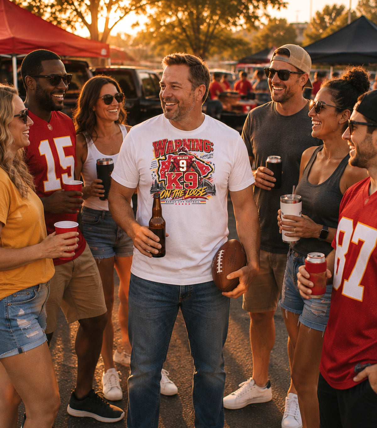 Man in white t-shirt with "K9 On The Loose" graphic, holding beer and football.