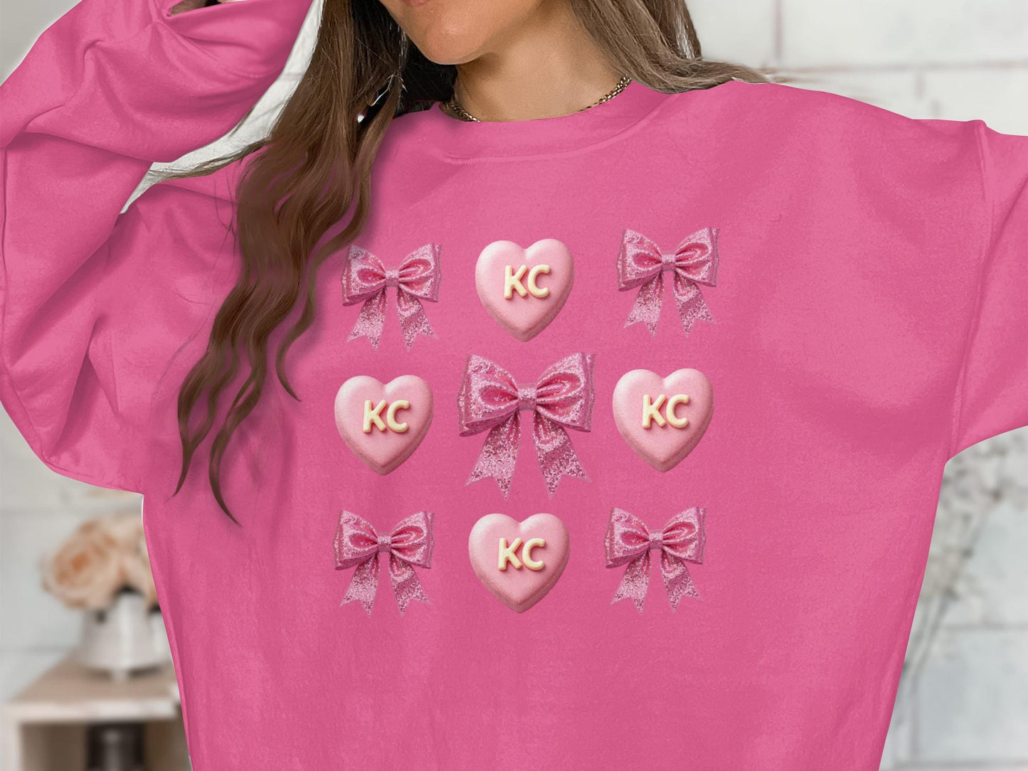 Pink sweatshirt with KC hearts and bows, trendy graphic top, cute casual wear, stylish design for everyday outfit, gift idea