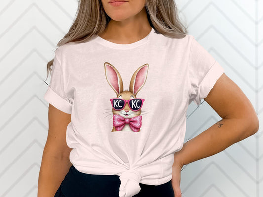 White t-shirt with a pink-nosed bunny wearing pink sunglasses and a pink bowtie.