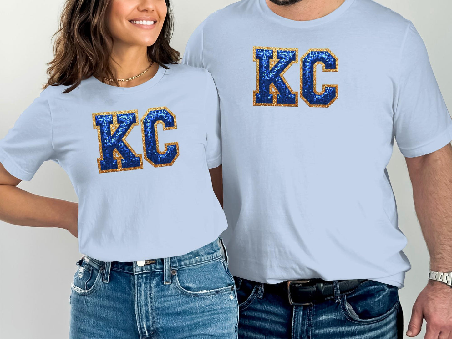 Two people in light blue t-shirts with "KC" in gold and blue sequins.
