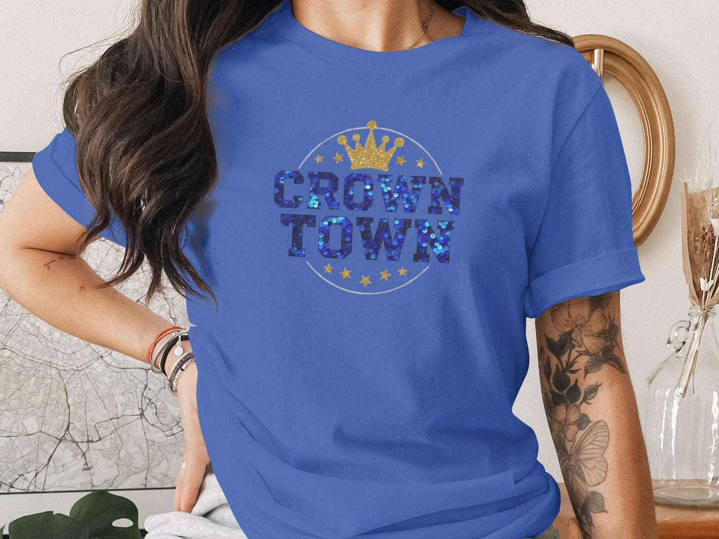 Blue t-shirt with "CROWN TOWN" in glittery blue letters and gold stars.