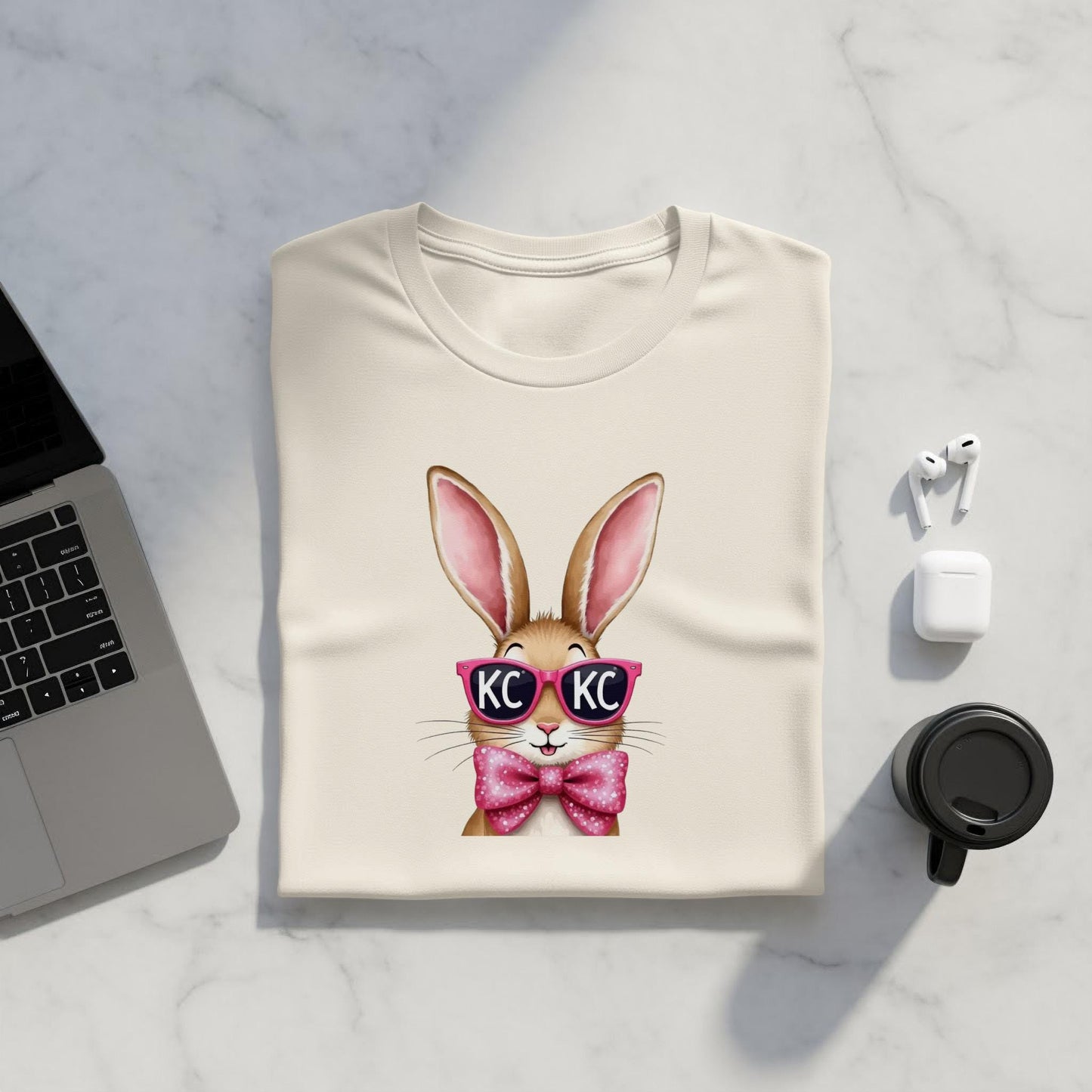 Cream t-shirt with a cartoon bunny wearing pink sunglasses and a bow tie.