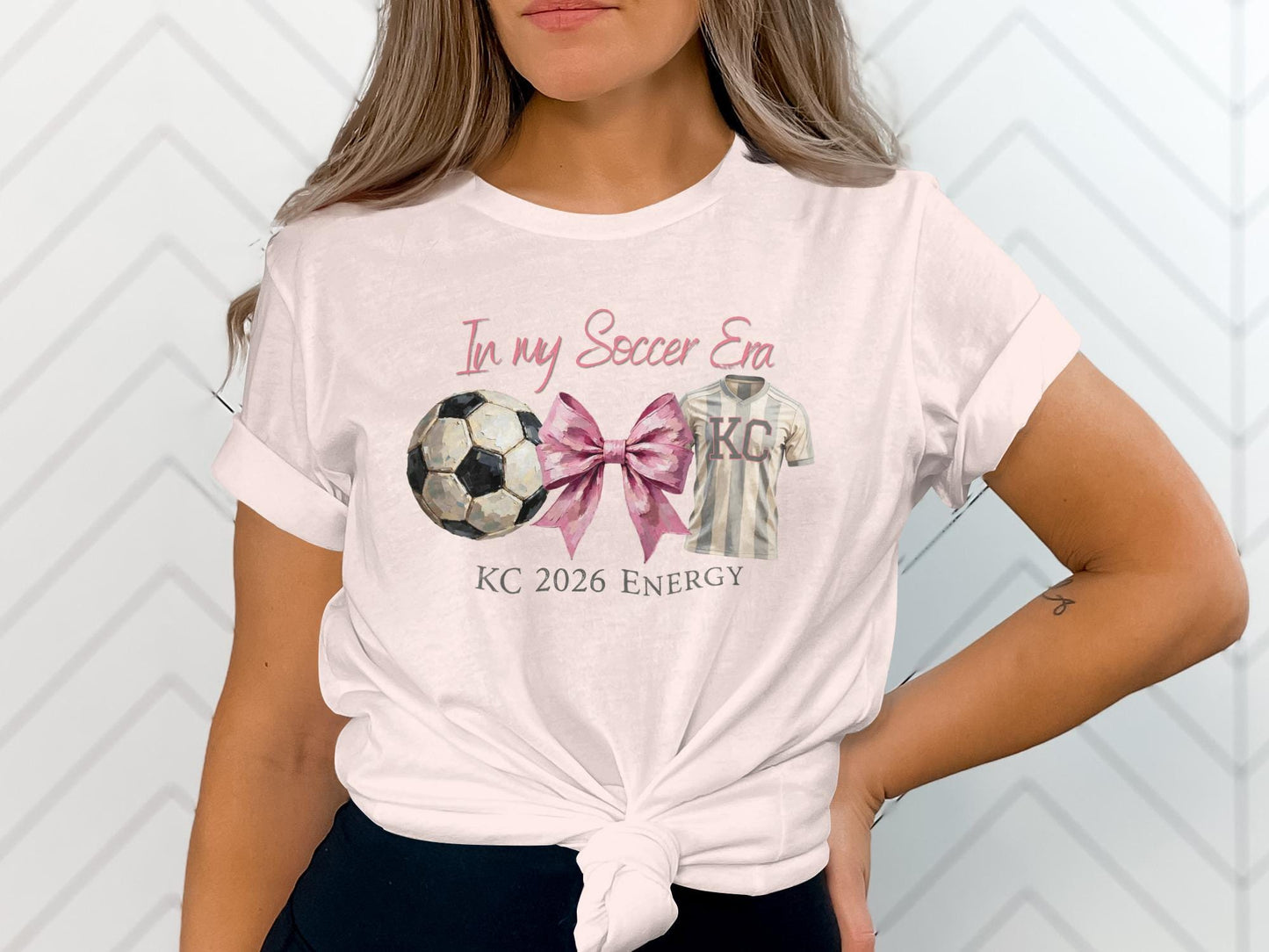 White t-shirt with "In my Soccer Era KC 2026 Energy" and soccer graphics.