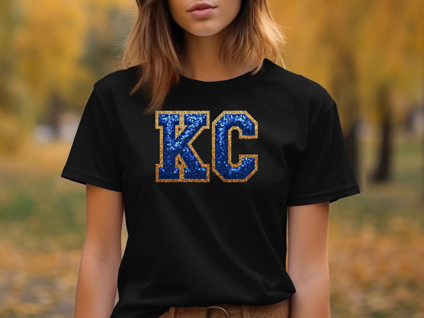 Black t-shirt with "KC" in blue and gold glitter.