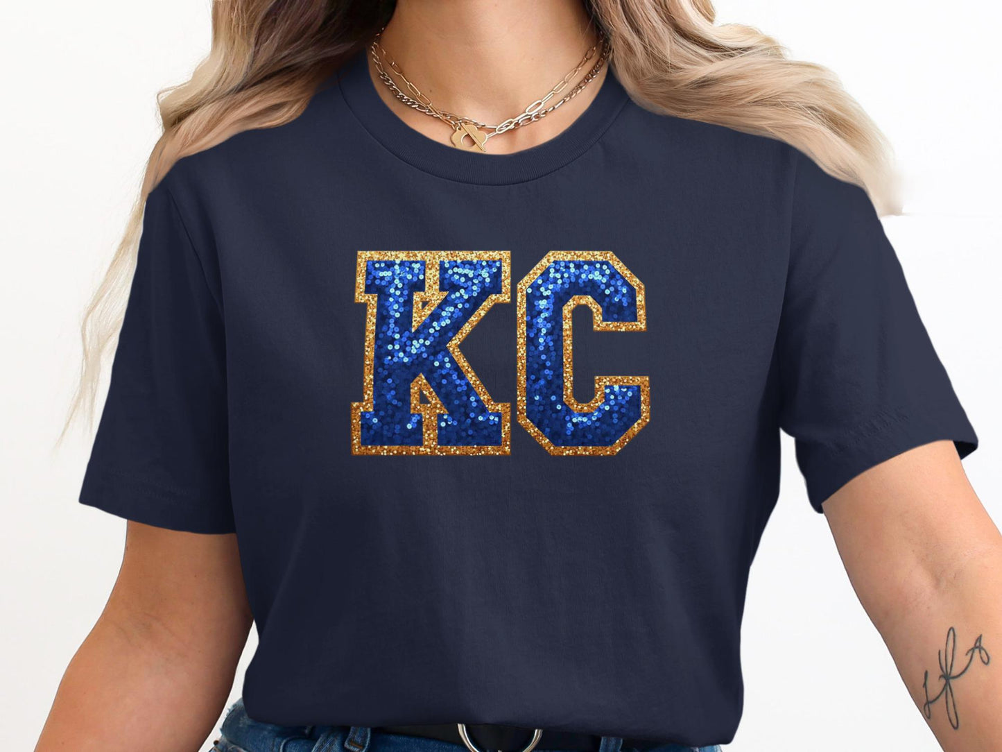 Navy t-shirt with glittery blue and gold "KC" lettering.