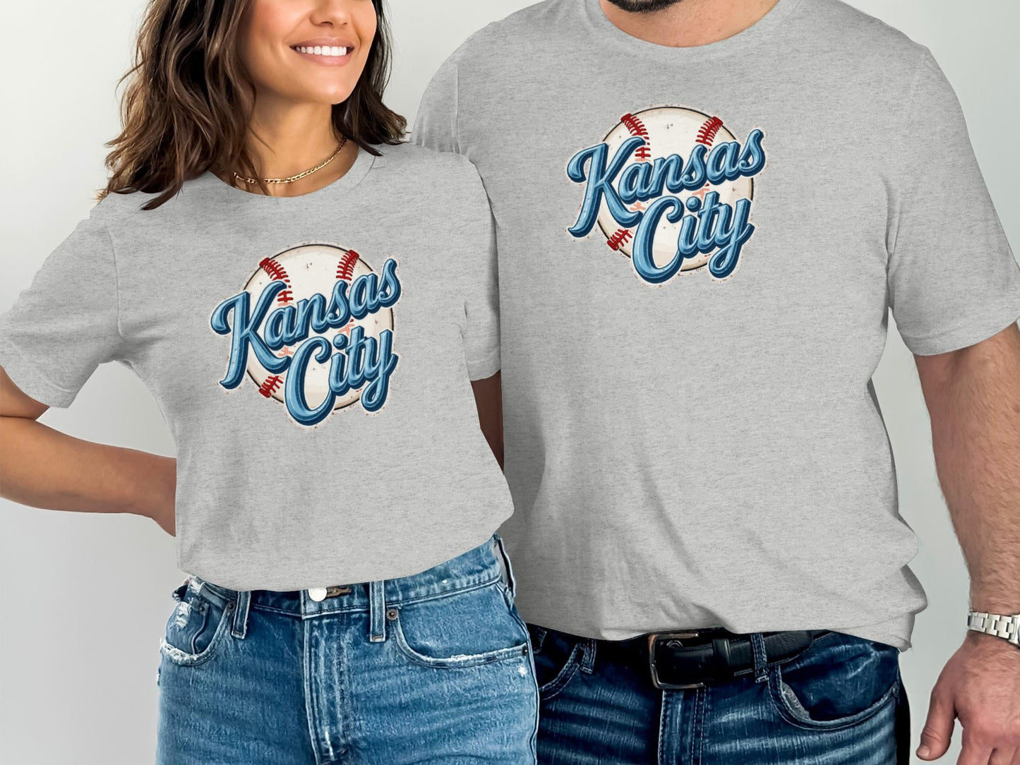 Two people wearing matching grey t-shirts with "Kansas City" baseball graphic.