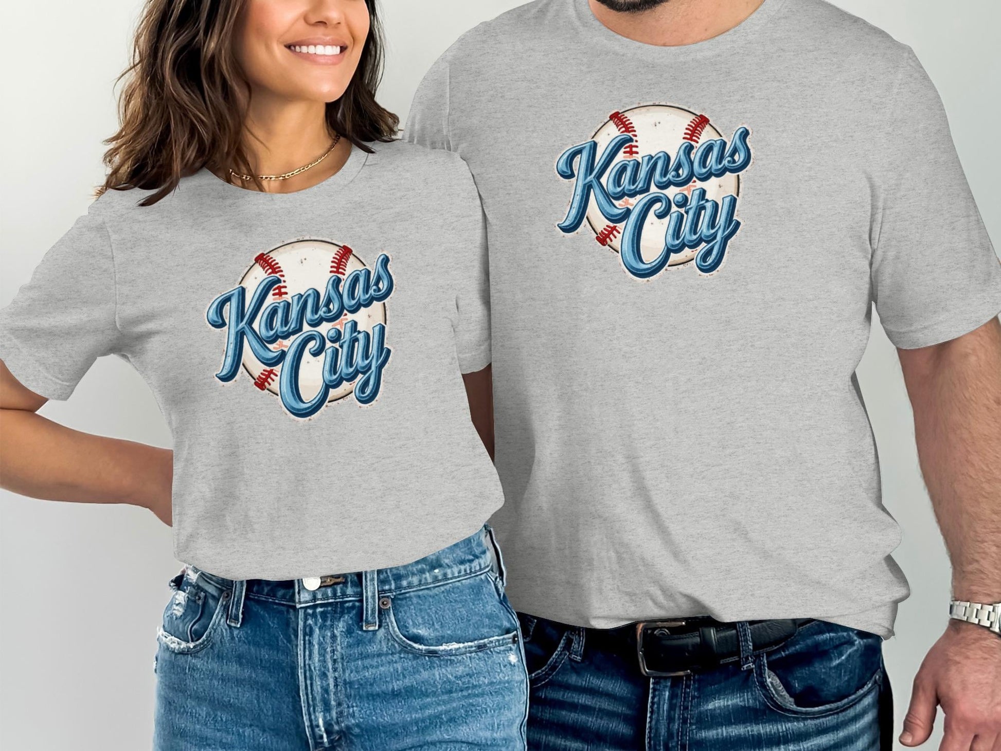 Two people wearing matching grey t-shirts with "Kansas City" baseball graphic.