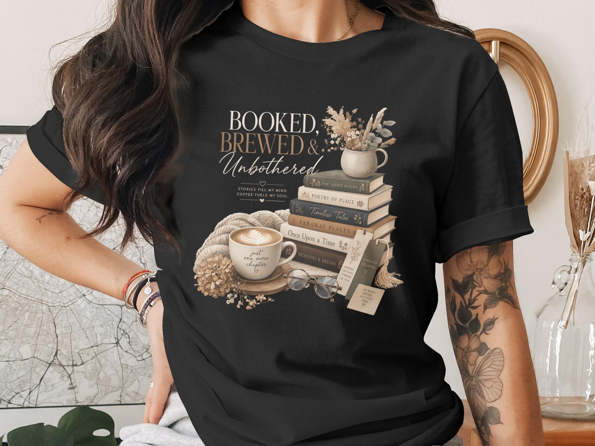 Black t-shirt with "BOOKED, BREWED & Unbothered" graphic and book stack.