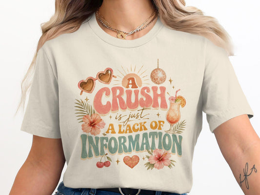 T-shirt graphic: "A crush is just a lack of information" with tropical elements.