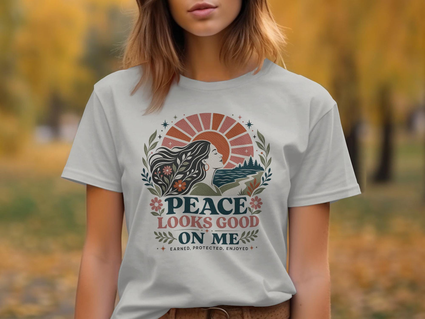White t-shirt with "Peace Looks Good On Me" graphic featuring a woman and nature design.