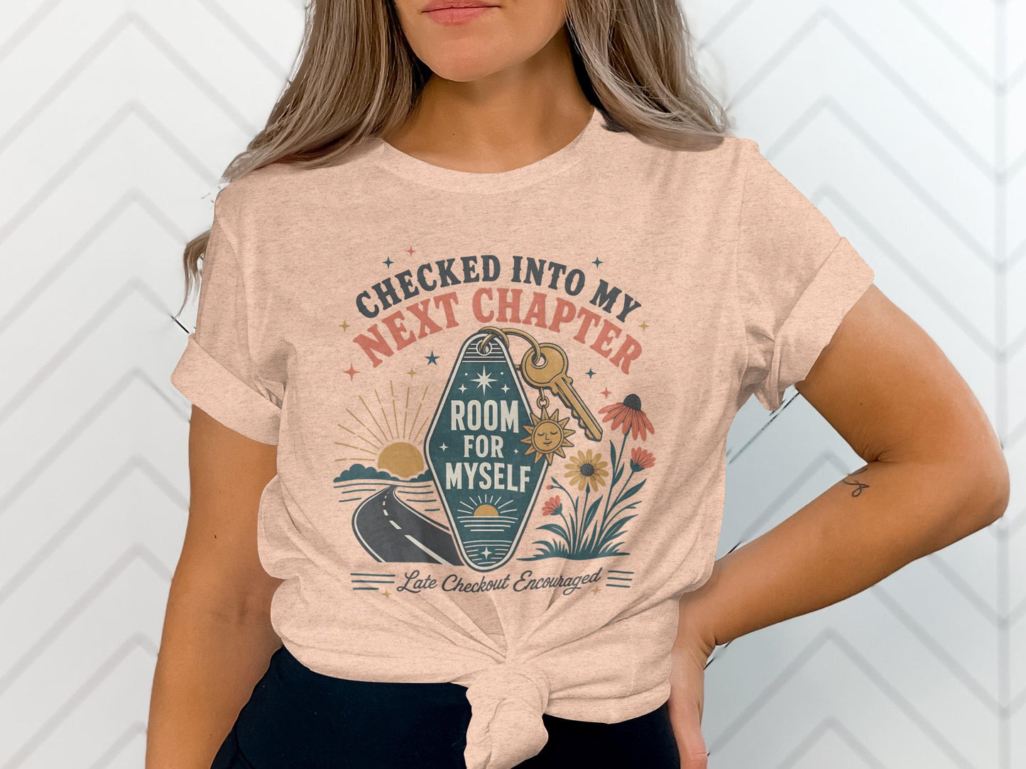 T-shirt with graphic: "Checked Into My Next Chapter," a key, and flowers.