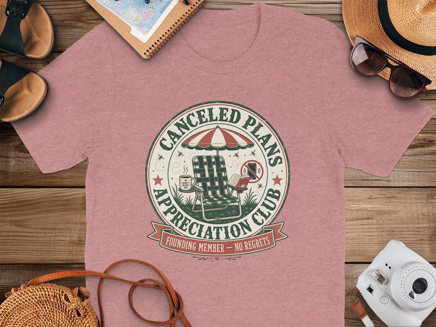 Pink t-shirt with a circular design for "Canceled Plans Appreciation Club" featuring a lounge chair.