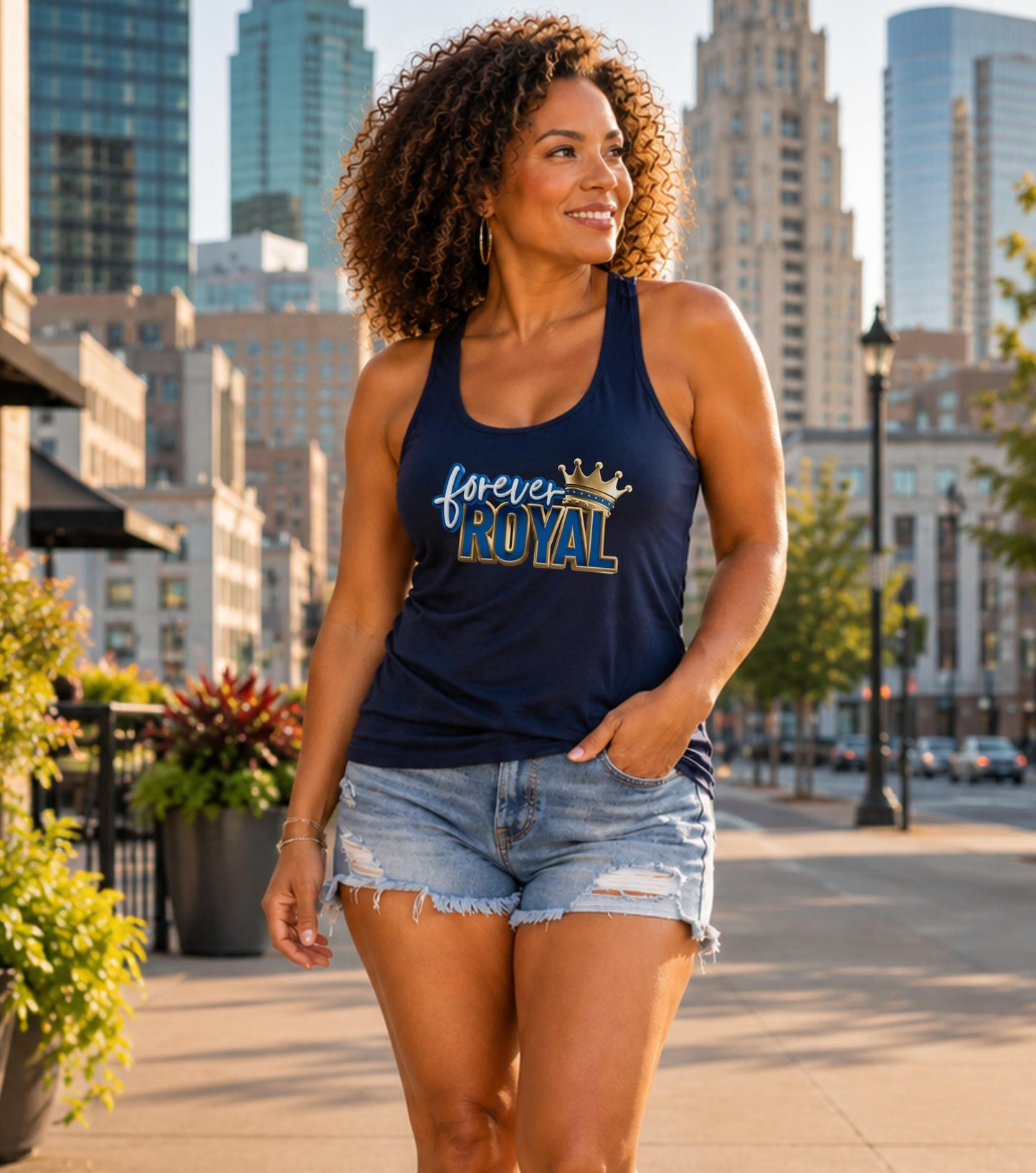 Woman in navy tank top with "forever ROYAL" graphic, denim shorts, walking outdoors.