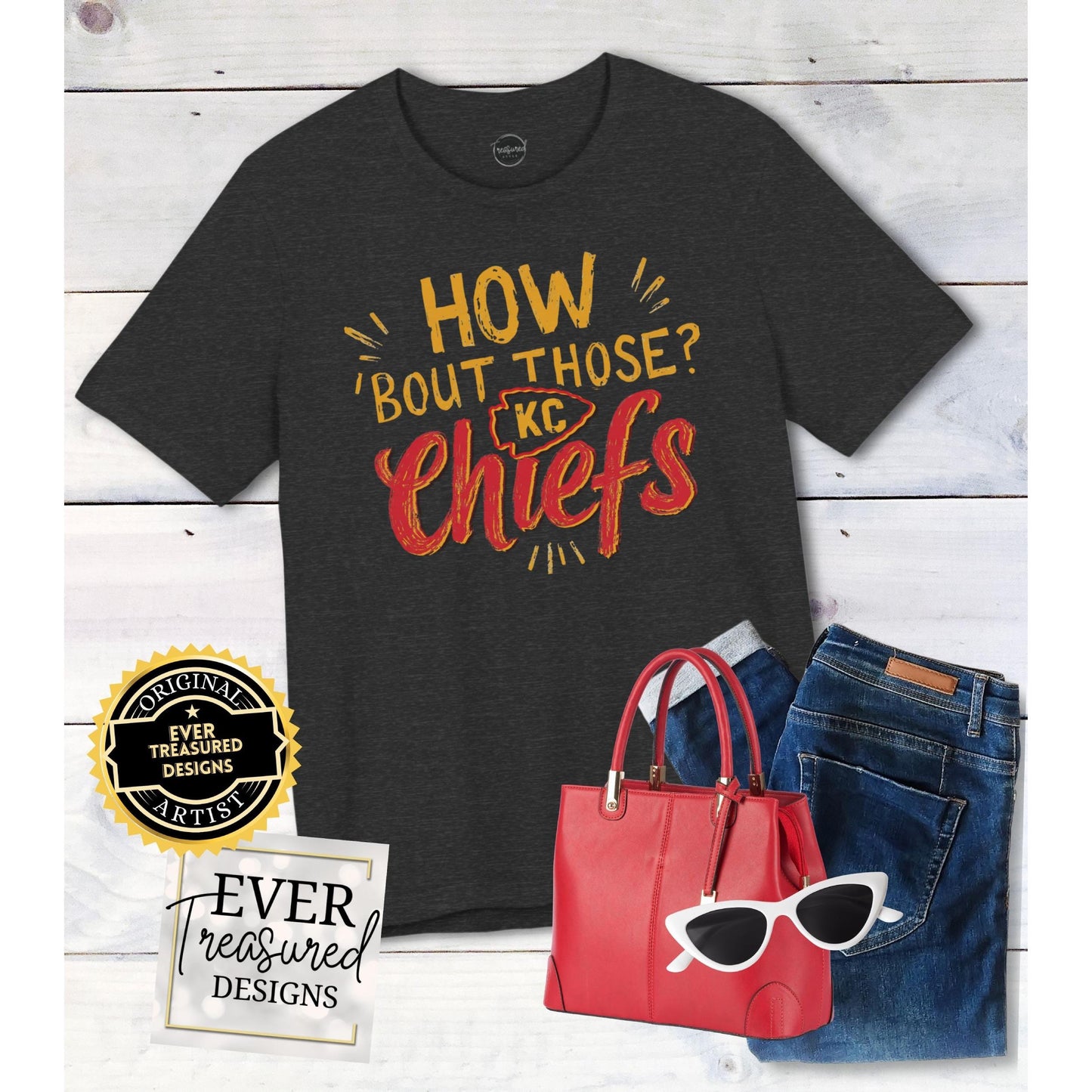 Dark t-shirt with "How 'Bout Those KC Chiefs" graphic, red handbag, jeans, and white sunglasses.