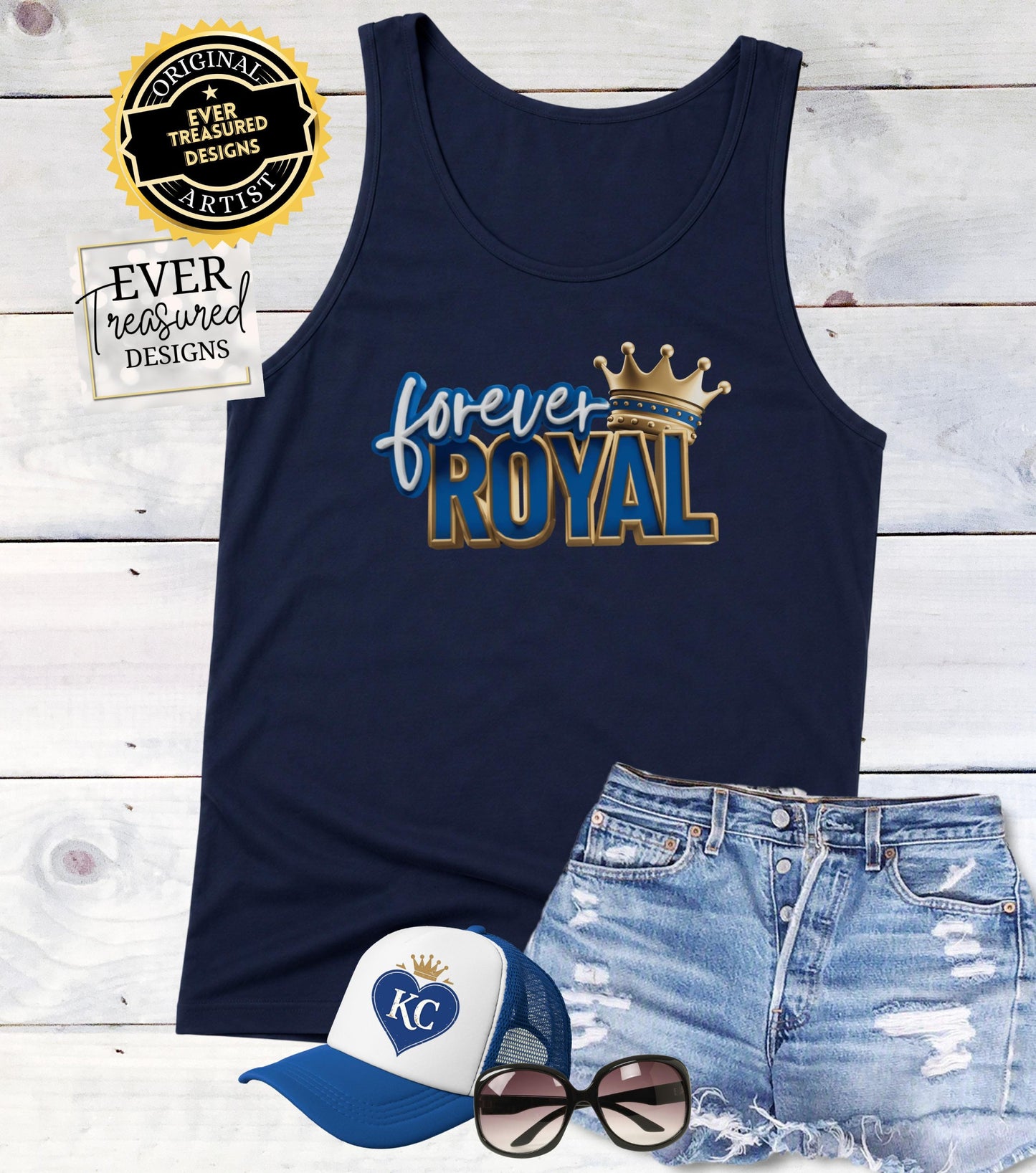 Navy tank top with "forever ROYAL" graphic and crown, flat lay with denim shorts, cap, and sunglasses.
