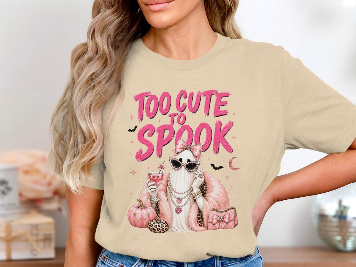 Ghost graphic on beige t-shirt with text "TOO CUTE TO SPOOK".