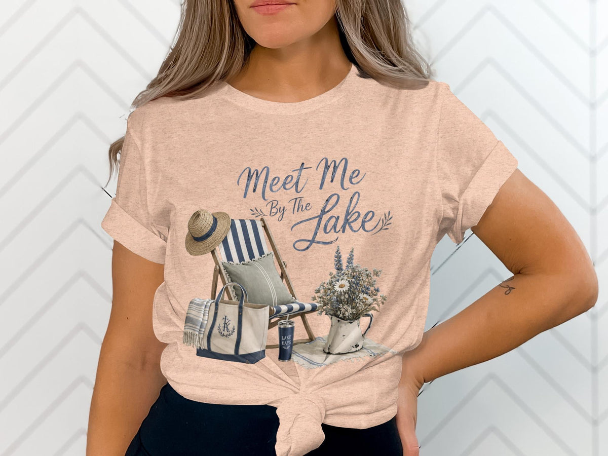 T-shirt graphic with "Meet Me By The Lake" text, deck chair, and tote bag.